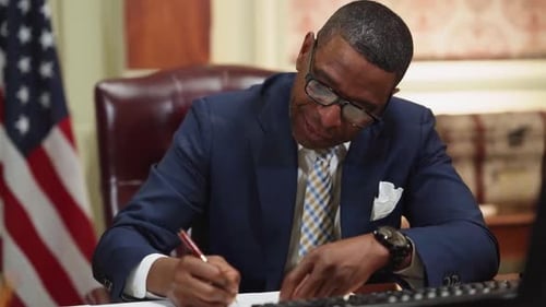 Man Writes at Desk with American Flag