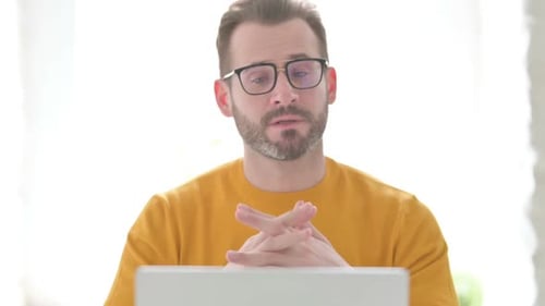 Man with Glasses Talking on Laptop Video Call