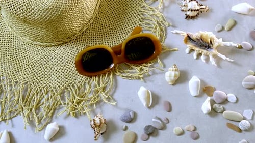 Female straw hat and sunglasses lie on beach sand. Travel summer accessories with copy space, flat
