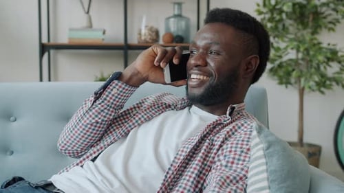 Man Relaxing on Sofa Talking on Phone
