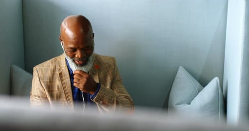 Senior Man in Office Talking on Headphones