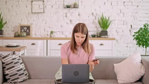 Woman Using Laptop and Credit Card at Home