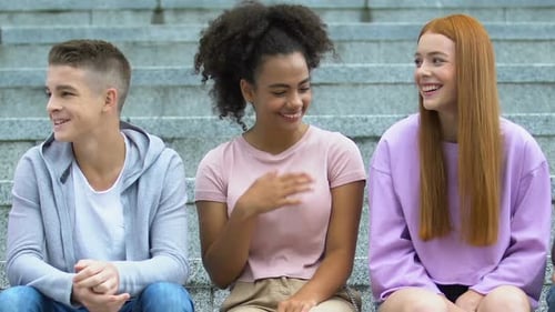 Multiethnische Gruppe männlicher und weiblicher Teenager, die reden und lachen, Freundschaft