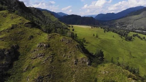 Aerial View. Sunny Mountain Landscape with Green Trees and Meadows