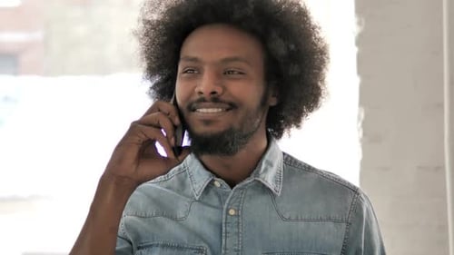 Young Adult Talking on Smartphone Indoors