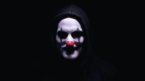 Menacing Clown with Hood Stares from Dark Space