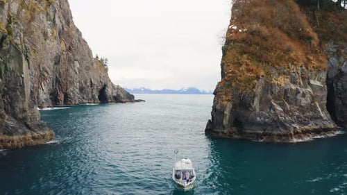 Scenic Aerial View of Boat Sailing Rocky Channel