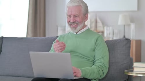 Older Man Video Calling on Laptop From Home