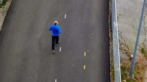 Man listening to music while jogging on the street, 4K 4k