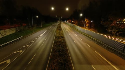 Highway traffic at night filmed from a bridge over it. Time lapse.