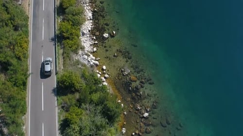 Car Driving Along the Coastal Road Above Rocky Shore