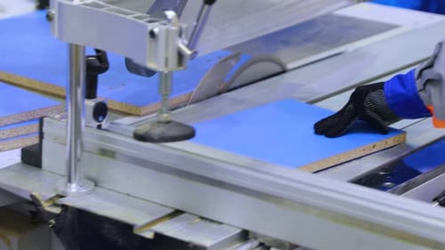 Industrial Saw Cuts Blue Material in Factory