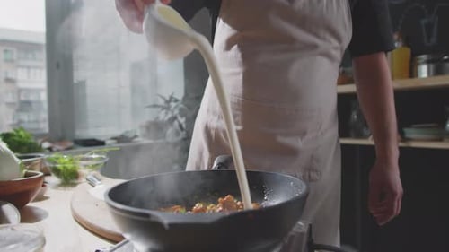 Chef Adds Sauce to Wok of Stir Fry