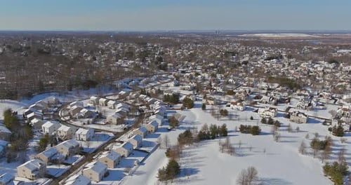 Aerial Top View Townhouse Settlement in Winter Snow Covered Rooftops of Cottages