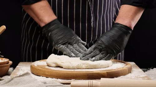 Chef Kneading Dough on a Wooden Board