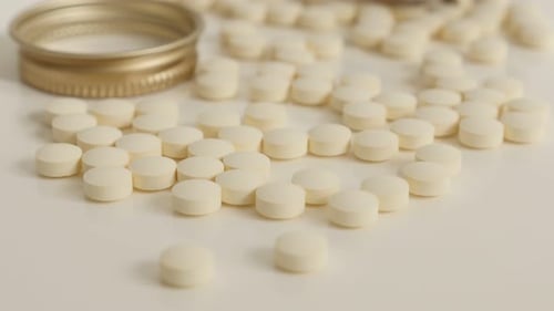Pile of small white tablets close up