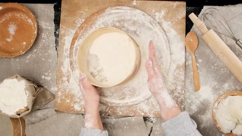 Overhead Shot of Hands Sifting Flour on Board