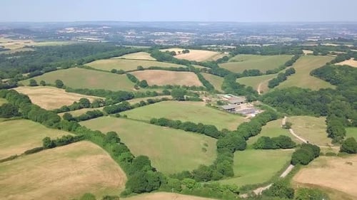Drone footage of vast green fields and meadows of a beautiful countryside landscape.