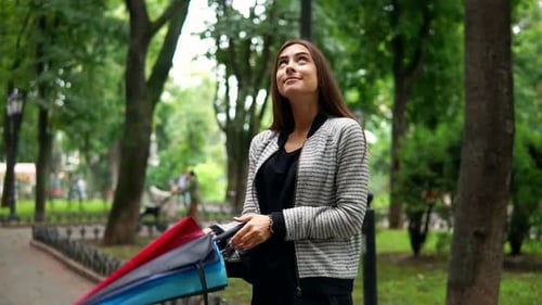 Woman Opens Colorful Umbrella in Urban Park