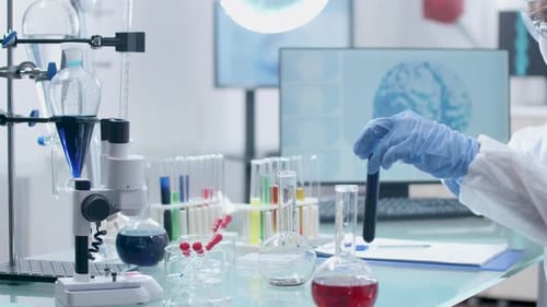 In High End Laboratory Scientist in Coverall Is Taking Sample From Tubes