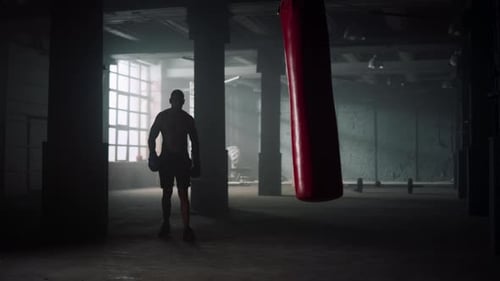 Man in Boxing Gloves Walking in Loft Building