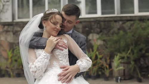 Newlyweds. Caucasian Groom with Bride Walking, Embracing, Hugs in Park. Wedding Couple