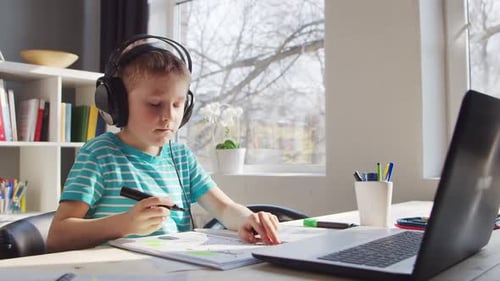 Boy Doing Homework at Desk with Laptop