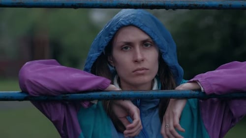 Young Woman Stands in Rain in Urban Area