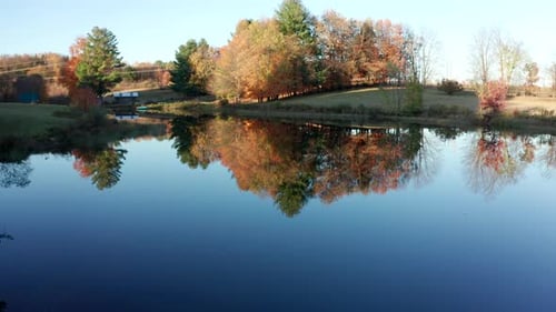 Aerial Drone Shot Flying Over Farm Pond with Fall Colors During Sunset