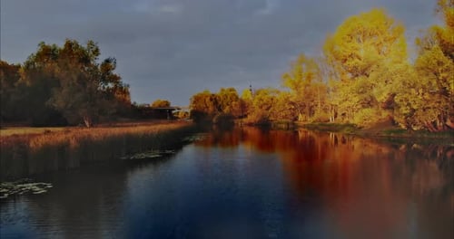 Aerial View a Copter Flies Over the Dark Water of a Rural River a Small Bridge in the Distance