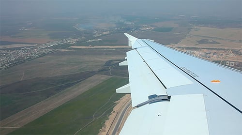 Aerial View From Airplane Over City on Sunny Day