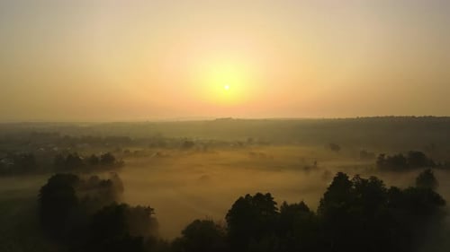 Aerial Landscape View of Sunny Morning Over Foggy Green Fields