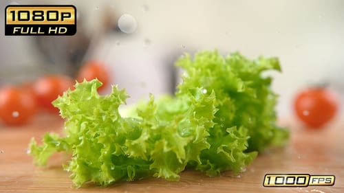 Crisp Lettuce Falling onto Cutting Board with Tomatoes
