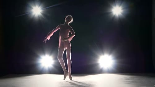 Ballerina Is Wearing Point Shoes on a Grey