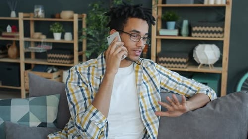 Young Adult Talking on Phone on Gray Couch