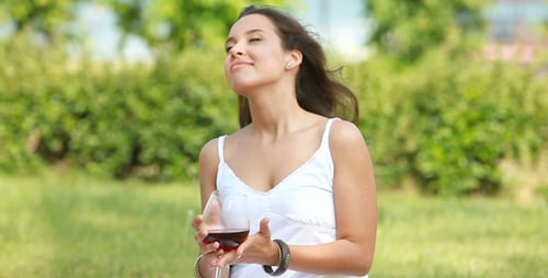 Woman Enjoys Wine Outdoors on a Sunny Day