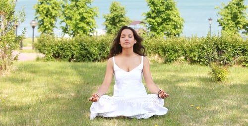 Woman Meditating Peacefully in a Sunny Park