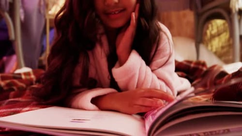 Girl relaxing on mattress and reading book