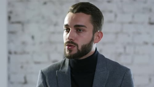 Man with Beard Wearing a Gray Blazer Talking