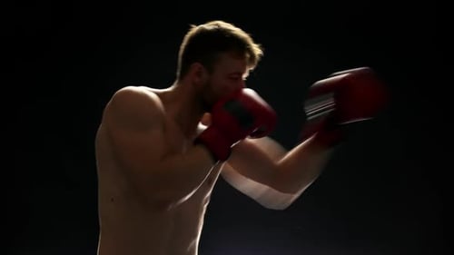 Athletic Boxer Fighting on Dark Background.