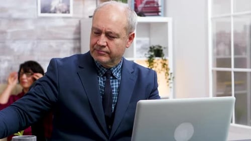 Older Man Types on Laptop in Home