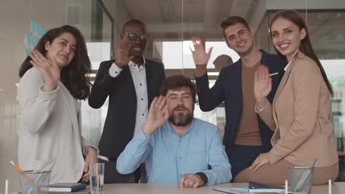 Cheerful Business Team Waving in Modern Office