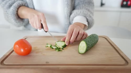 Cutting Cucumber on a Wooden Cutting Board