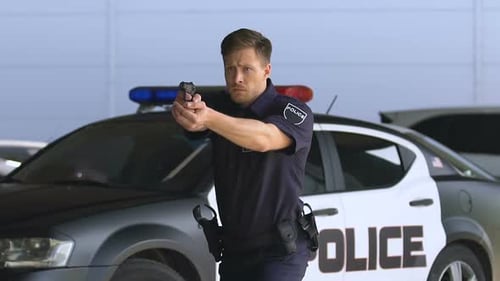 Young Police Officer Aiming Gun, Detaining Criminal Outdoors, District Security