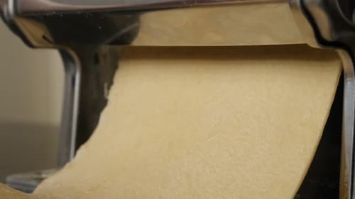 Dough Being Fed Through Pasta Roller