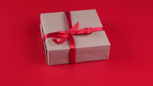 Wrapped Gift With Red Ribbon on Red Background