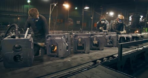 Men are grinding parts on the creek. Heavy male labor. Metallurgical industry. Car engine factory