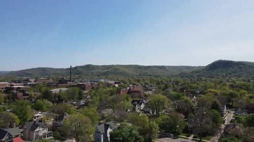 Drohnenblick über etablierte Nachbarschaft im Mittleren Westen der Stadt mit Klippen und strahlend blauem Himmel.