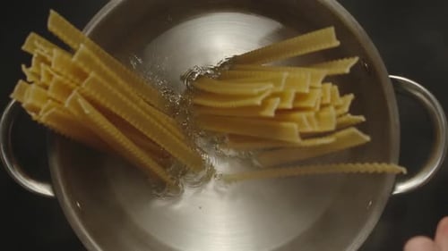 Adding Uncooked Pasta to Pot of Boiling Water