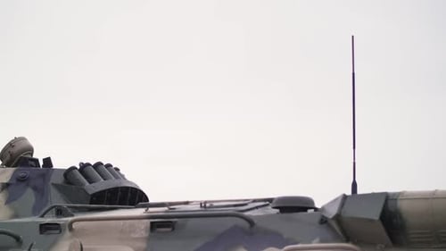 Camouflaged Military Vehicle with Gun and Antenna